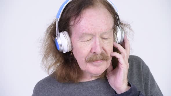 Senior Man with Mustache Listening To Music
