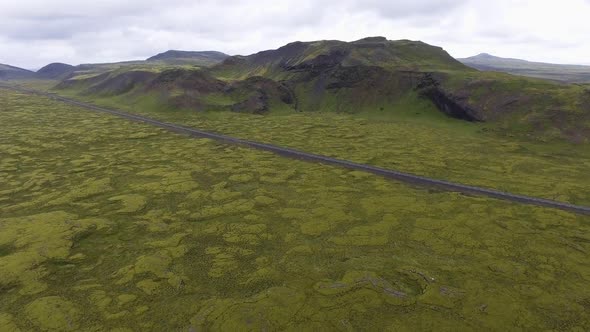 Aerial View of Road Through Mossy Lava Field in Iceland