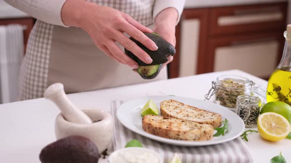 Woman Hands Open Ripe Cut in Halves Avocado Fruit