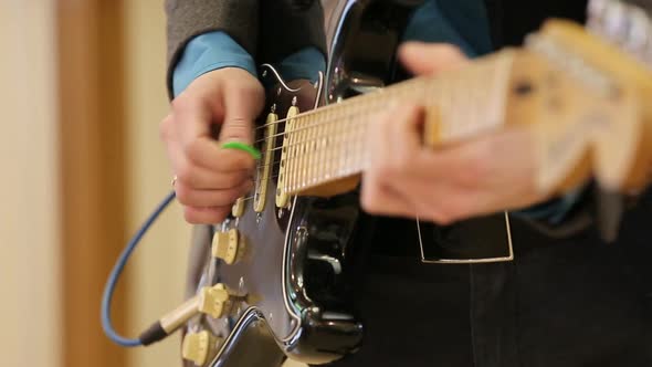 Men's Hands Play the Electric Guitar. Close-up of a Musician Playing the Guitar. Fingers on Guitar