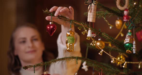 Woman Decorating Beautiful Christmas Tree in Living Room