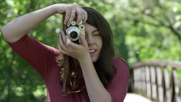 Young woman taking photo with vintage film camera