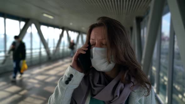 Woman Is Listening To Good News By Mobile Phone, Standing in Pedestrian Tunnel, Wearing Face Mask