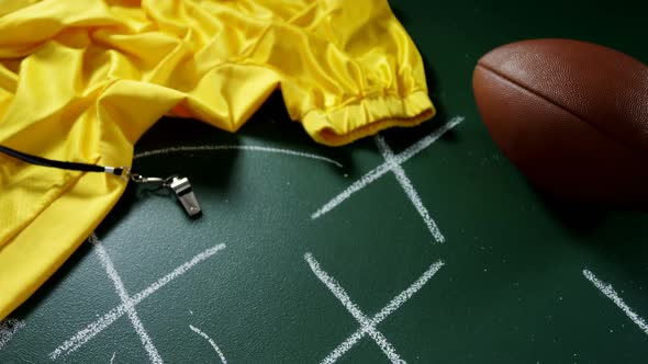 Jersey, whistle and football on green board 