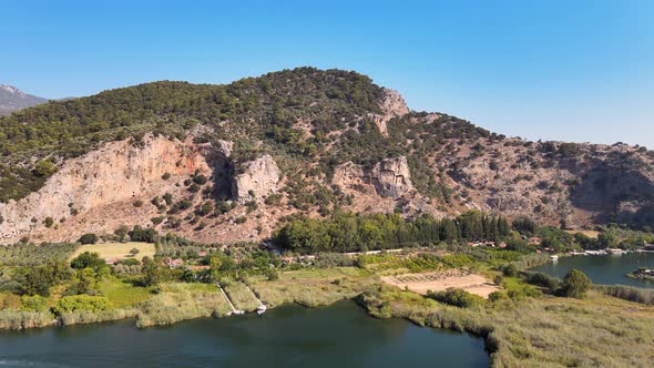 Drone shooting of a mountain temple and the vicinity of the city of Dalyan flying over the fields an