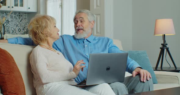 Old Retired Couple Using Laptop Doing Internet Shopping Choose Sale Offers Together Senior Elderly