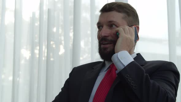 Portrait Senior Business Man with a Beard in an Expensive Suittalking on the Phone in the