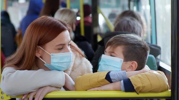 Woman with Male Children Wearing Medical Mask To Protect Against Virus and Infection Lie on