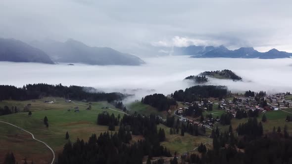 Aerial Dolly Back View Over Arvenbuel In Switzerland With Dramatic Mist