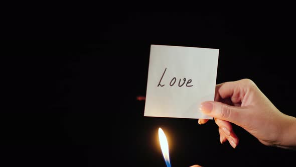 Man Burns a Paper with the Inscription Love