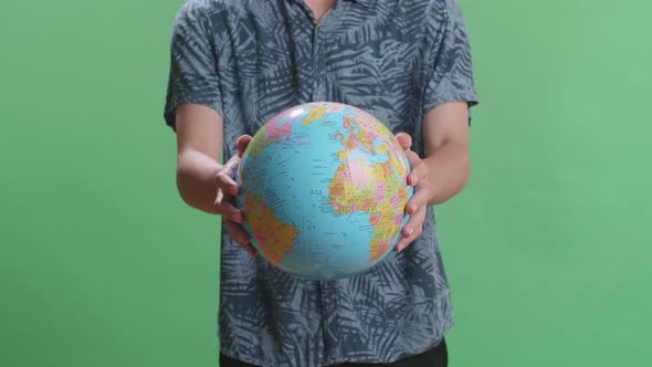 A Man In Front Of Green Screen Background Hand In The World Globe To The Camera