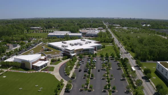 Aerial drone shot over a long highway beside parking lot in front of Salvation Army for the Ray and