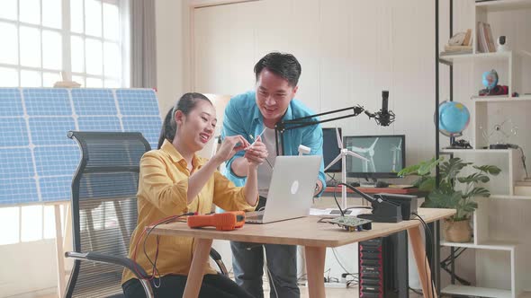 Asian Man And Woman Discuss About Work With Wind Turbine And Laptop Computer