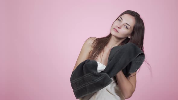Brunette Woman Dries Long Hair with Towel Isolated on Pink Background