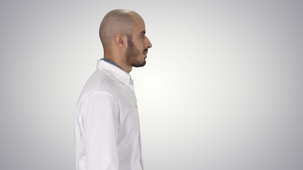 Arabian Doctor in White Robe Walking on Gradient Background