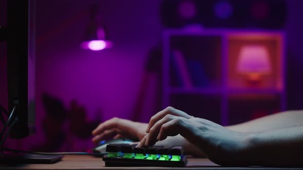 Gamer Typing on Backlight Keyboard Closeup Man Playing Video Game