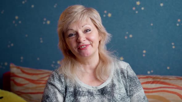 Portrait of friendly senior woman waving hand and looking at camera with happy face smiling