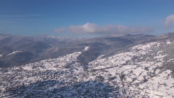 Scenic Landscape of Small Town Among Forest and Mountain Valleys in Winter Carpathians Aerial Drone