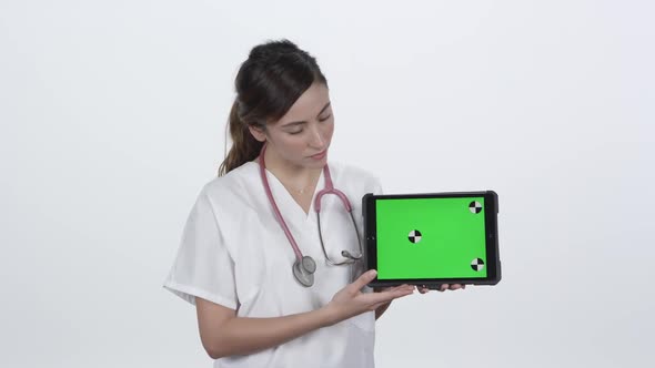 Doctor referencing results on tablet with green screen