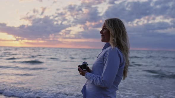 Photographer Using Camera On Beach At Sunset