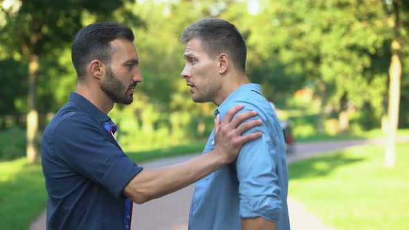 Angry Men Pushing and Threatening Each Other Outdoors Solving Problem With Force