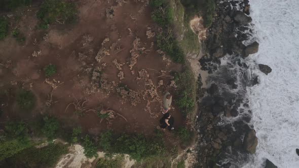 Aerial View of Rocky Cliff Landscape with Ocean and People on Cliff Top