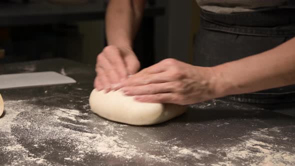 Cinematic Live Camera Shot Female Hands of a Baker with Professional Quick Movements Kneads the