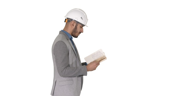 Young architect reading textbook or notebook while walking