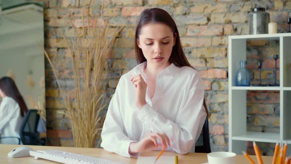 Beautiful Young Businesswoman Working on Computer at Her Working Place in Office