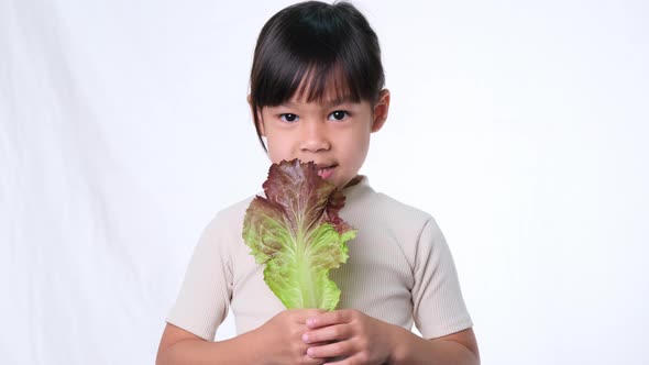 Children do not like to eat vegetables. Little girl who hates eating green salad.