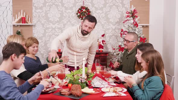 Man Pouring Champagne in Glasses for His Family