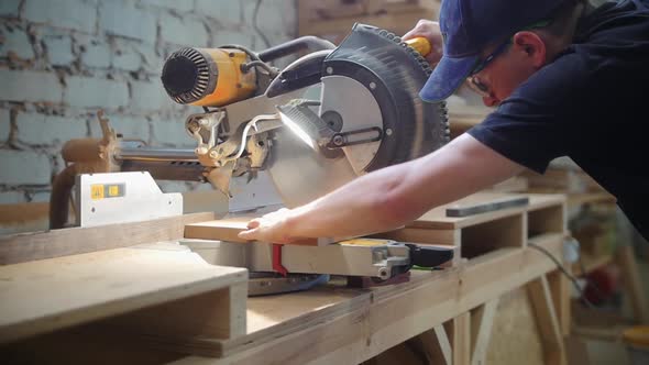 Carpentry Workshop  Man Worker Cutting on the Wooden Desk Using a Big Circular Saw