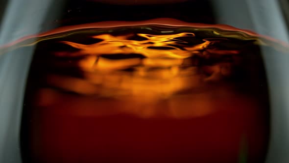 Super Slow Motion Detail Shot of Rippling Whiskey in Glass at 1000Fps.