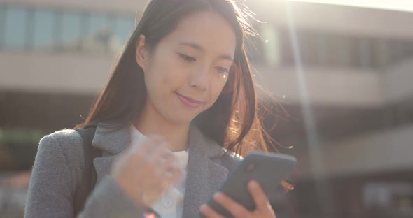 Asian Business woman look at smart phone in city