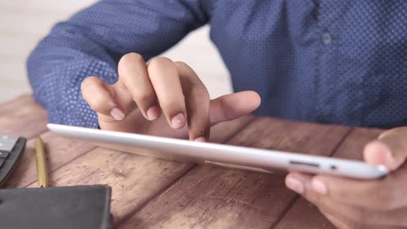 Man's Hand Working on Digital Tablet at Office Desk Using Self Created Chart