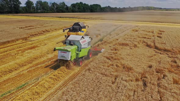 Aerial view of combine harvesters. High angle shot of harvesters working in the field