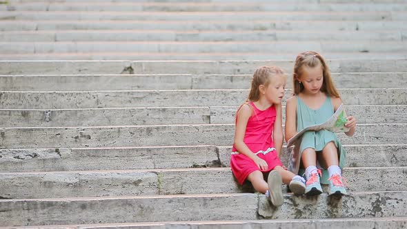 Little Girl Looking at Touristic Map in Roman Streets in Italy