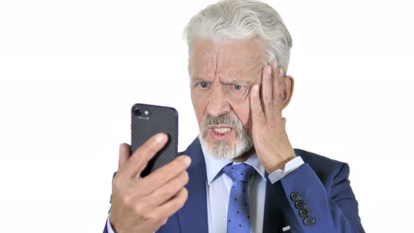 Old Businessman Upset by Loss on Smartphone, White Background