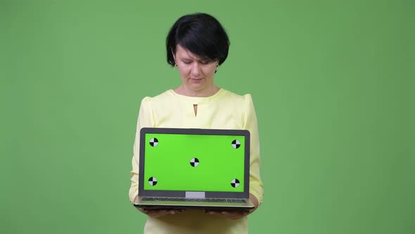 Beautiful Businesswoman with Short Hair Showing Laptop