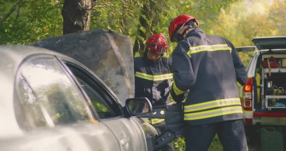 Firemen Disassembling Damaged Car After Accident