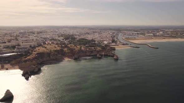 Rocky cliffs surrounding the marvelous Burgau beach in Portugal. Aerial