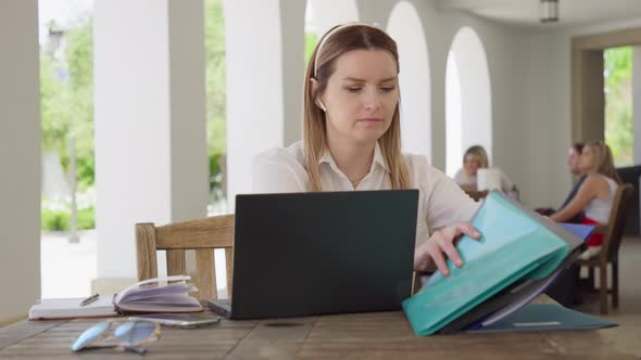 Concentrated Successful Businesswoman Reviewing Paper Documents and Contracts