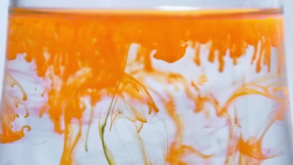 Orange Paint Ink Drops Drips Flow in Water Fluid