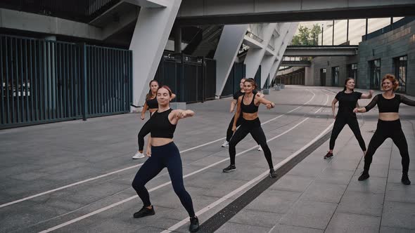 Diverse Group of Six Stylish Professional Dancers Performing a Latin Dance Routine in Front of City