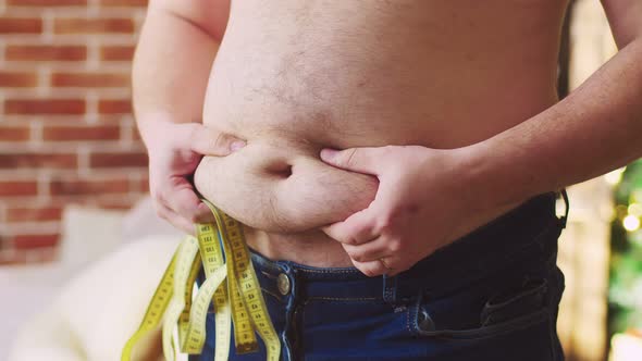 Men's Hands Touch Stomach Showing Excess Weight