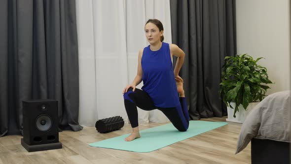 Female stretches hamstring muscles, leg muscles with pigeon pose.