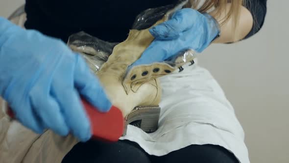 A Woman Cleans Shoes in Her Apartment