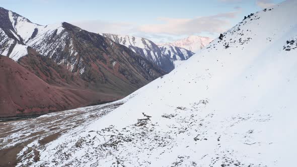 A Beautiful Aerial Drone Footage of Mountainside Covered with White Pure Snow Then Getting Close to