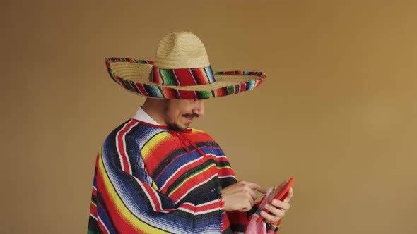 Young Mexican In Multicolored Poncho And Hat