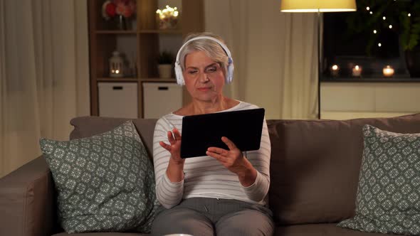 Senior Woman in Headphones Listening To Music